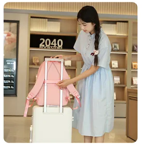 Vue detaillee du sac a dos rose avec une sangle de valise pour un usage quotidien.