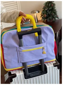 Gedetailleerd overzicht van een kleurrijke reistas met kofferriem, ideaal voor trips.