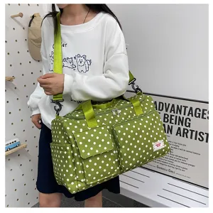Grand sac de voyage vert à pois pour femmes, avec poches multiples et bandoulière pratique.
