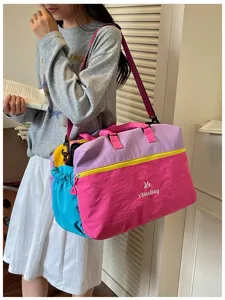 Dettaglio della borsa da viaggio colorata, con tessuto multicolore e spallacci robusti.