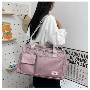 Vue détaillée du grand sac de voyage gris à pois roses avec poches de rangement.
