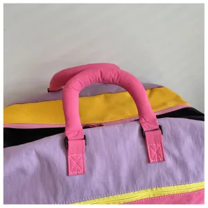 Primo piano del manico colorato della borsa da viaggio e del design a pannelli multicolore.