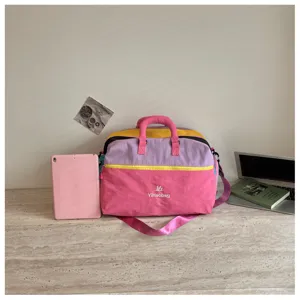 Vista dettagliata della borsa da viaggio colorata in tela su una scrivania moderna.