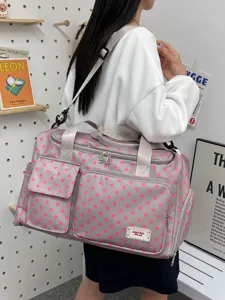 Grand sac de voyage pour femmes, design élégant à pois roses avec bandoulière pratique.