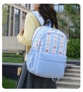 Gros plan d'un sac à dos d'étudiant bleu clair avec un motif mignon d'ours et d'étoiles.