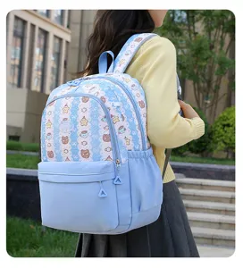Vue détaillée du joli sac à dos bleu pour étudiant avec motif d'ours et bretelles.