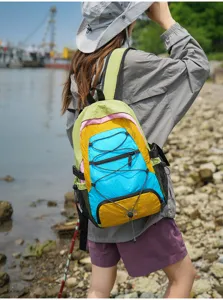 Outdoor travel color-block backpack detail showing vibrant multi-color design and elastic cord.