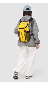 Detail view of the yellow and purple color-blocking lightweight outdoor hiking backpack with mesh side pockets.