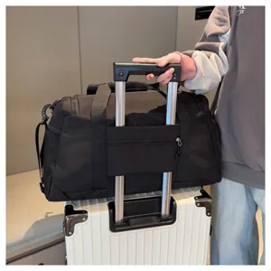 Détail de sac de voyage avec passant pour valise assurant une fixation facile sur le trolley.