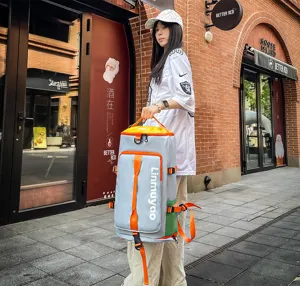 Détail de scène de rue extérieure d'un sac à dos de voyage multifonction avec sangles orange.