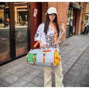 Vue de détail lifestyle en extérieur montrant le grand sac de voyage multicolore.