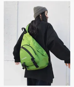 Gedetailleerd overzicht van de groene schouderrugzak gedragen door model, met voorzak.