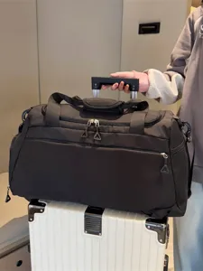 Grand sac de voyage multifonctionnel avec compartiment chaussures et sangle de valise.