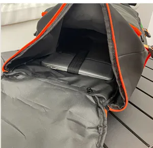 Vue détaillée du sac à dos de voyage noir avec fermetures éclair orange et compartiment.