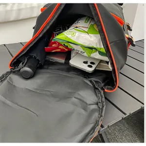 Vue détaillée d'un grand sac à dos de voyage noir avec des fermetures éclair orange.