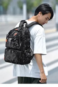 Detail view of the camouflage tactical backpack with bright orange zipper pulls for outdoor.