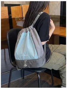 Detailansicht des karierten Kordelzug-Rucksacks mit nassem und trockenem Trennfach für Sport.