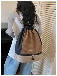 Nahaufnahme des karierten Kordelzug-Rucksacks mit unterem Reißverschluss-Nassfach.