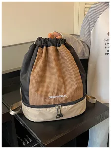 Detailaufnahme des Kordelzug-Rucksacks mit Karomuster, Nass-Trocken-Trennung und Bodenfach.