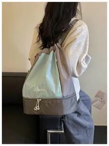 Detailaufnahme des stilvollen Kordelzug-Rucksacks mit Karomuster und Nassfach unten.