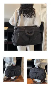 Black travel duffel bag detail, large capacity, durable fabric, convenient shoulder strap and handles.