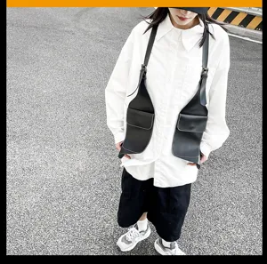 Streetstyle Detailaufnahme der schwarzen PU Leder Schultertasche mit Tragegurten.