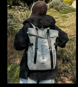 Detail view of the stylish grey roll-top waterproof backpack outdoors, perfect for street fashion.
