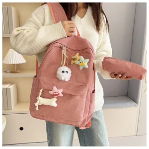 Dettaglio dello zaino scolastico rosa in corduroy con ciondoli carini e astuccio.