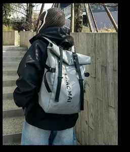 Urban street style waterproof roll-top backpack detail shot, grey fabric with black straps.