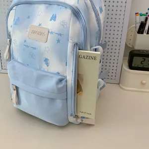 Lichtblauwe bedrukte schoolrugzak met schattig strikjespatroon voor dagelijks gebruik.