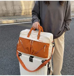 Detail view of the large capacity travel duffle bag with color block design and front pockets.
