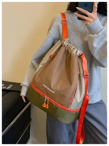 Detailansicht des Kordelzug-Rucksacks mit Karomuster, wasserdichter Tasche und Gurten.