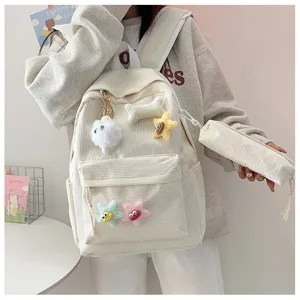 Dettaglio dello zaino scolastico in velluto a coste con ciondoli in peluche e comodo astuccio.