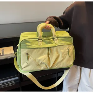 Large capacity travel duffel bag detail, light green patchwork design, practical zipper.
