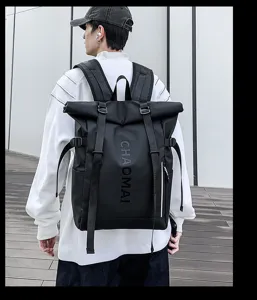 Detail view of the black roll-top waterproof backpack showing webbing and zipper pocket design.