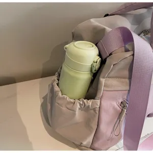 Detail view of women travel duffel bag side pocket with water bottle holder storage.