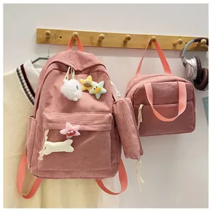 Vista dettagliata del set zaino rosa in velluto a coste con simpatici ciondoli di peluche.