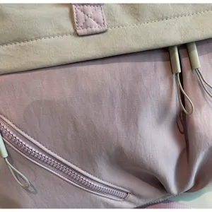 Detailed view of women's large travel duffel bag fabric, pink and grey contrast storage bag.