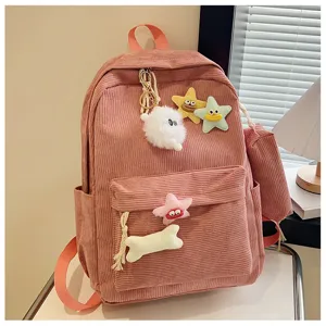 Dettaglio zaino rosa in corduroy con simpatiche stelle di peluche e ciondoli decorativi.