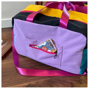 Color block travel duffel bag, casual gym bag with crossbody strap and front pocket detail.