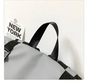 Detailed view of grey backpack top handle and tag, ideal for outdoor travel gear.