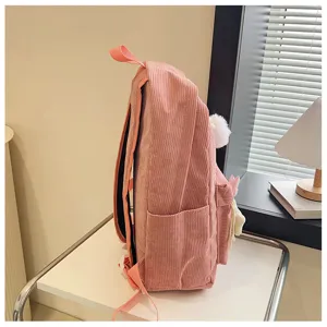 Dettaglio laterale zaino in velluto a coste rosa borsa scuola con pon pon morbido.
