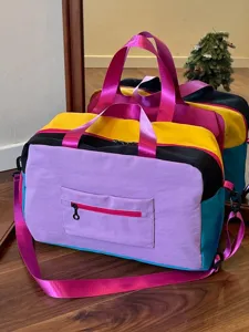 Vibrant colorblock duffel bag for women, stylish travel gym tote bag with adjustable crossbody strap.