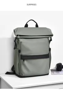 Detailed view of grey roll-top backpack with black leather trim, side pockets and zipper.