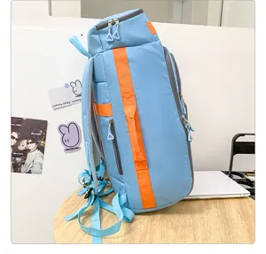Vue de profil du sac à dos de voyage bleu bicolore avec des bretelles et poches orange vif.