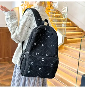 Sac a dos noir en velours cotele avec motifs de noeud blanc et beau design tendance.