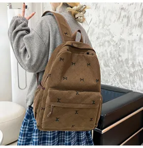 Vue détaillée d'un joli sac à dos en velours côtelé marron avec nœuds pour l'école et les voyages.