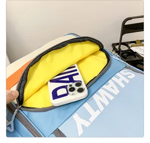 Gros plan sur la poche avant du sac à dos de voyage colorblock avec doublure jaune.