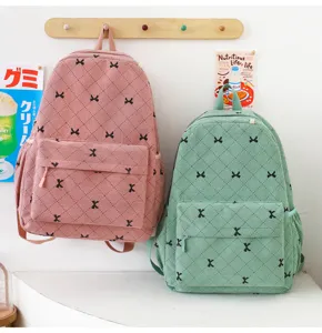Vue détaillée de sacs à dos en velours côtelé avec motifs de nœuds et poches pratiques.