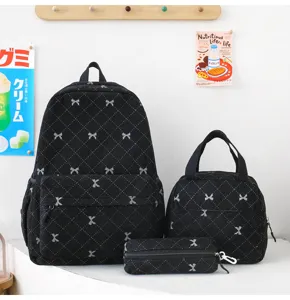 Vue détaillée du set de sac à dos d'école en velours côtelé noir avec motifs de nœuds.